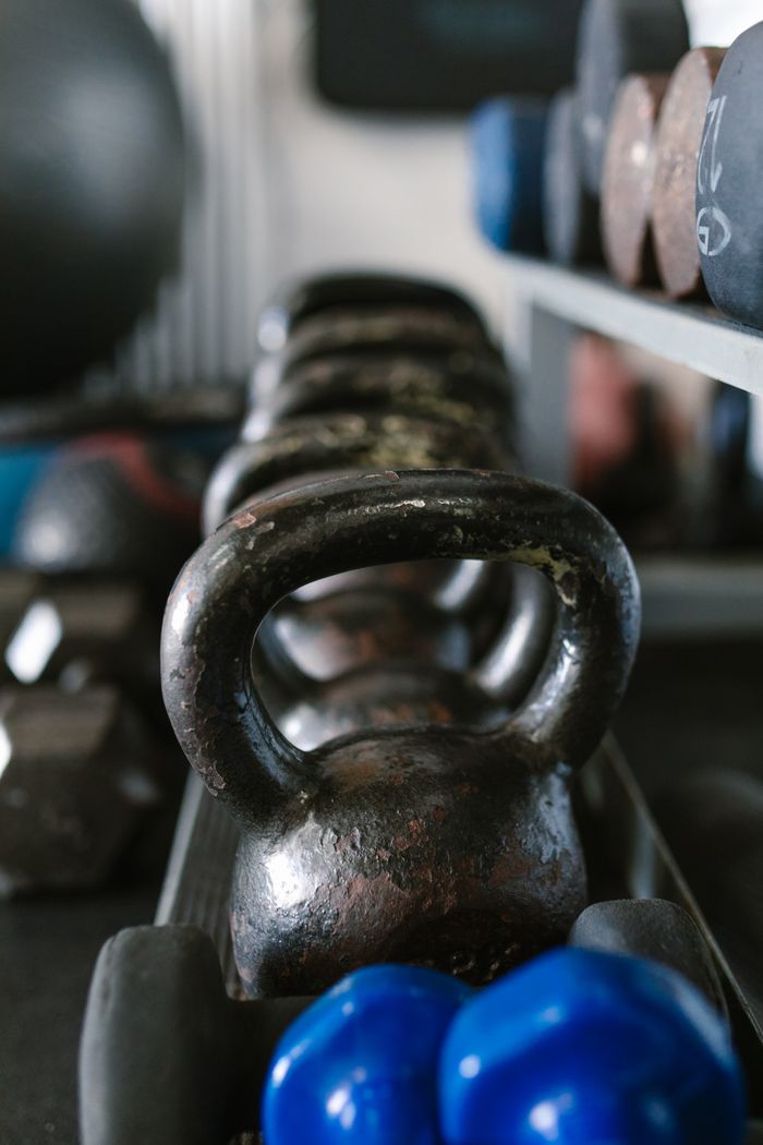 services-04 A close view of kettlebells and weights, showcasing essential gym equipment for strength training.
